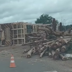 Carreta tomba na rotatória de acesso ao shopping e espalha carga de madeira na rodovia