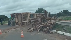 Carreta tomba na rotatória de acesso ao shopping e espalha carga de madeira na rodovia