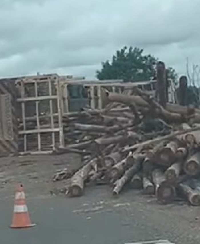 Carreta tomba na rotatória de acesso ao shopping e espalha carga de madeira na rodovia